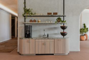 A modern kitchen with a wooden counter and a black fridge.
